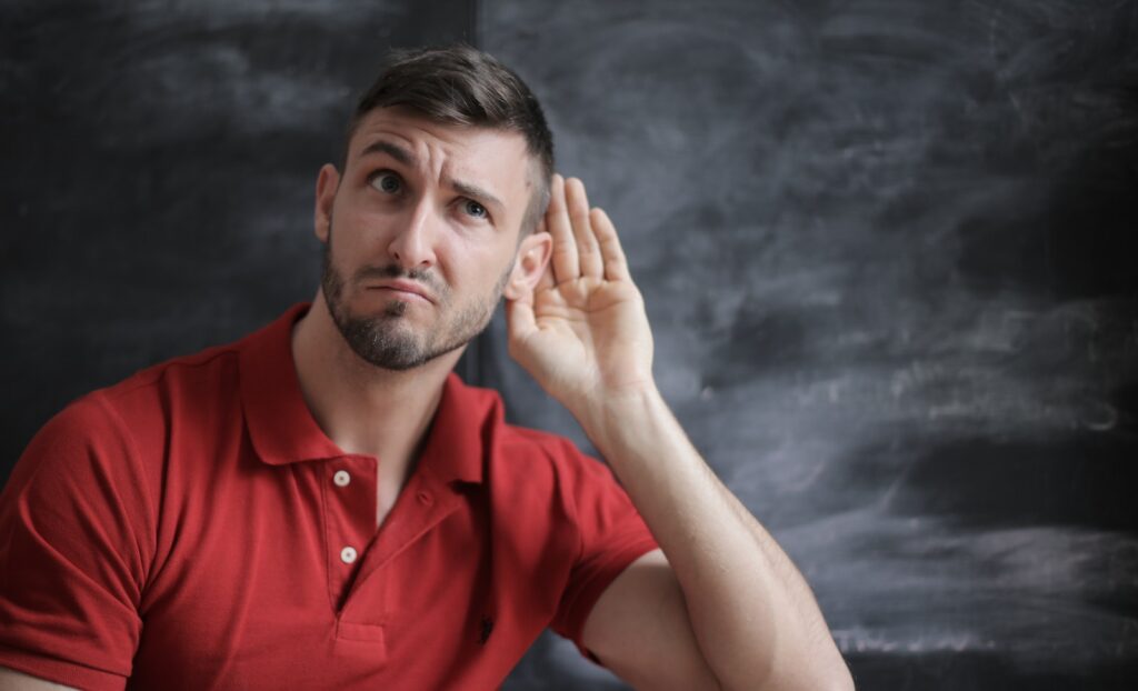 ActiveListening Man in Red Polo Shirt Sitting Near Chalkboard